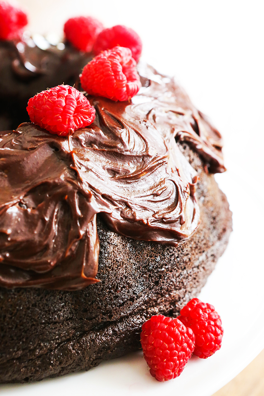 Chocolate bundt cake topped with chocolate frosting and topped with fresh raspberries