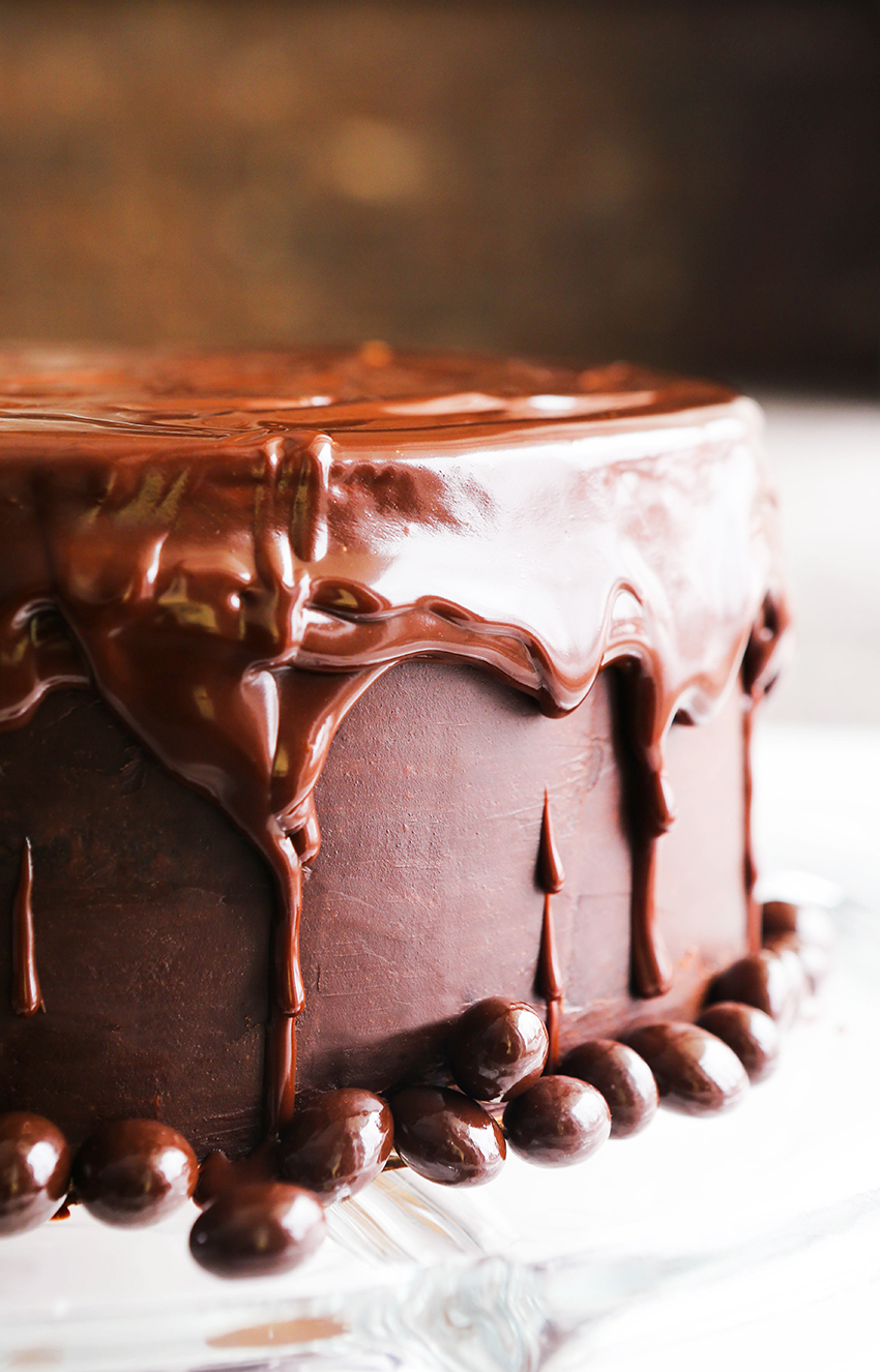 Chocolate ganache dripping down sides of a chocolate layer cake