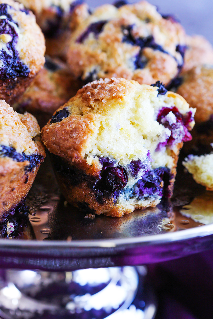 close up of homemade blueberry muffins, one with center exposed