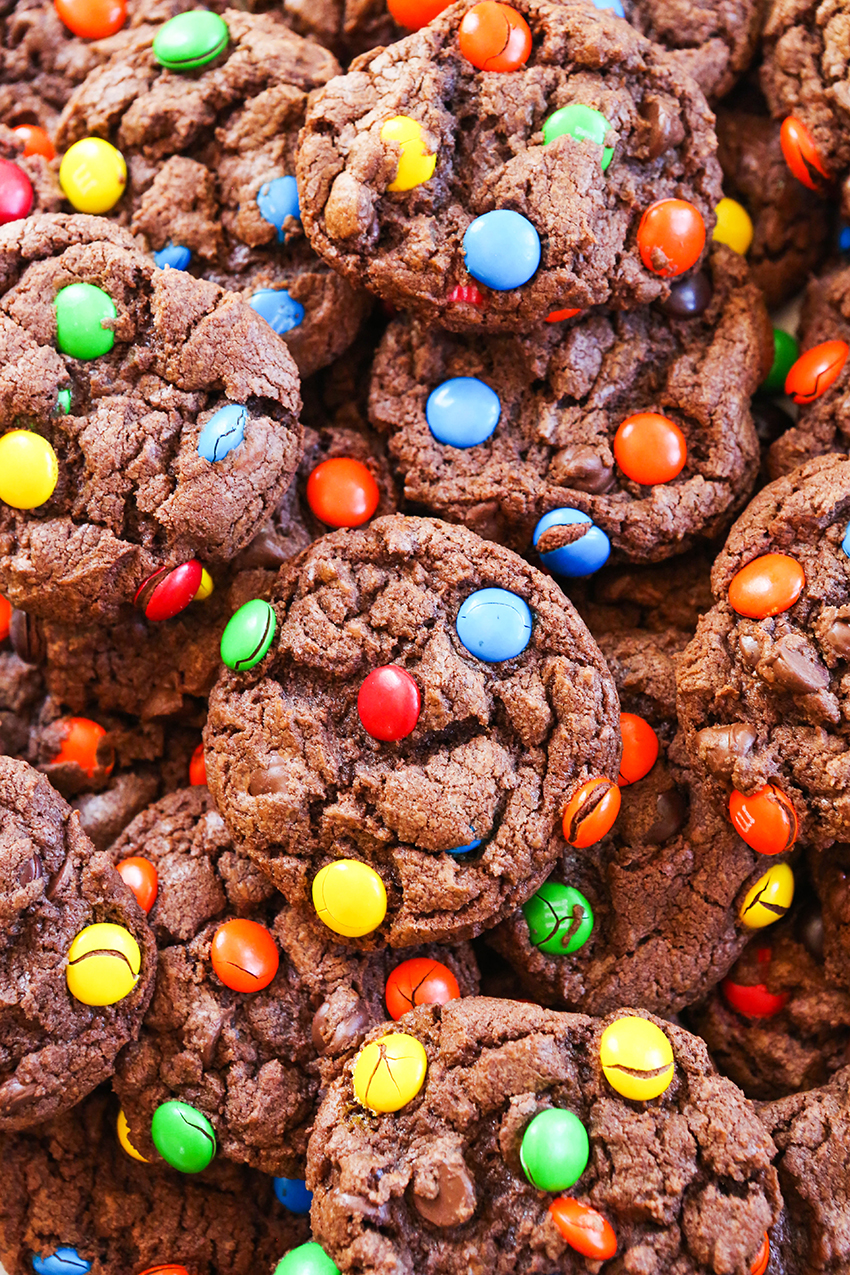 close up top view of chocolate M&M's cookies stacked in a huge pile