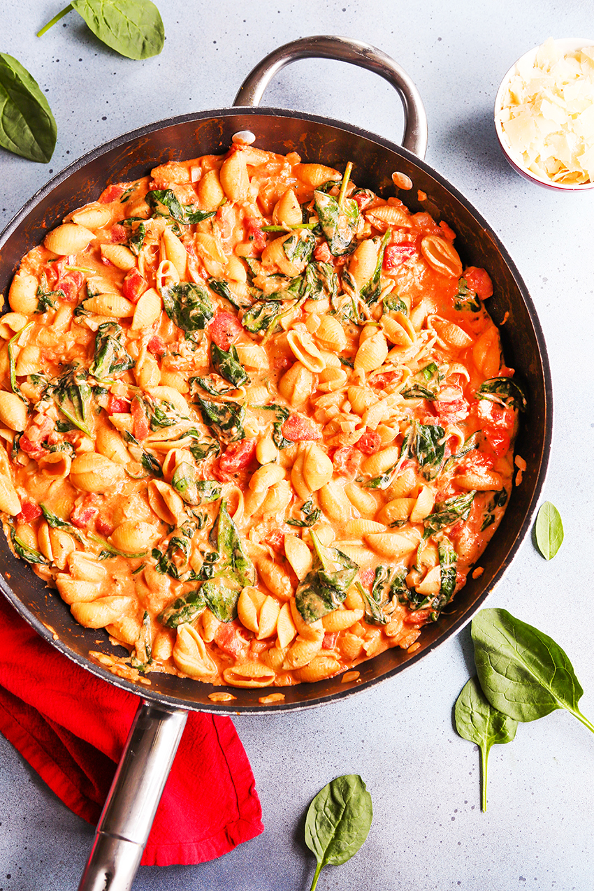skillet full of tomato pasta and spinach