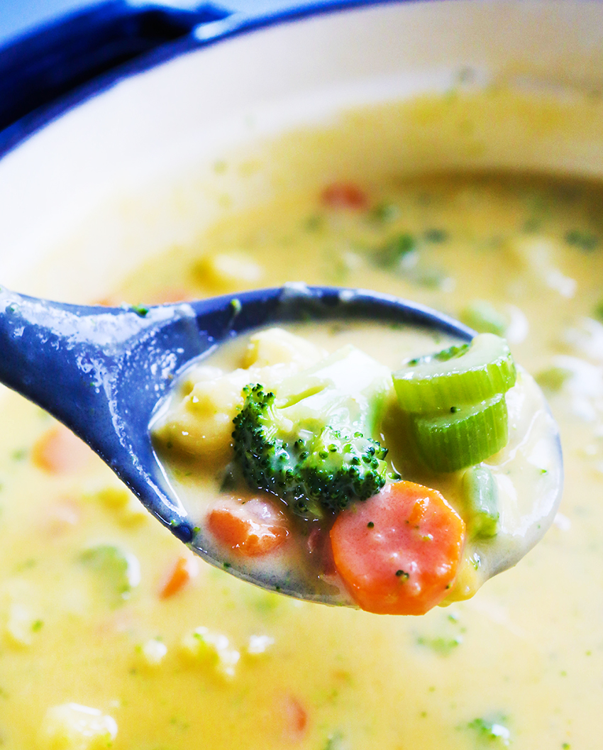 spoonful of cheesy soup with veggies