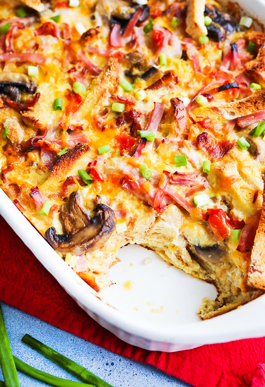 Serving removed from a baking dish filled with christmas breakfast casserole