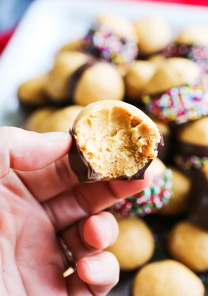 hand holding a buckeye ball with a bite taken out of it
