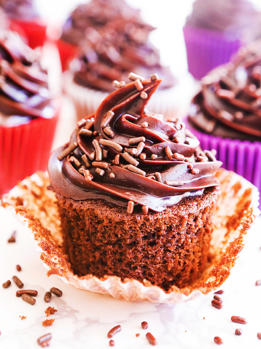 Perfect chocolate cupcake piled high with frosting surrounded by other cupcakes