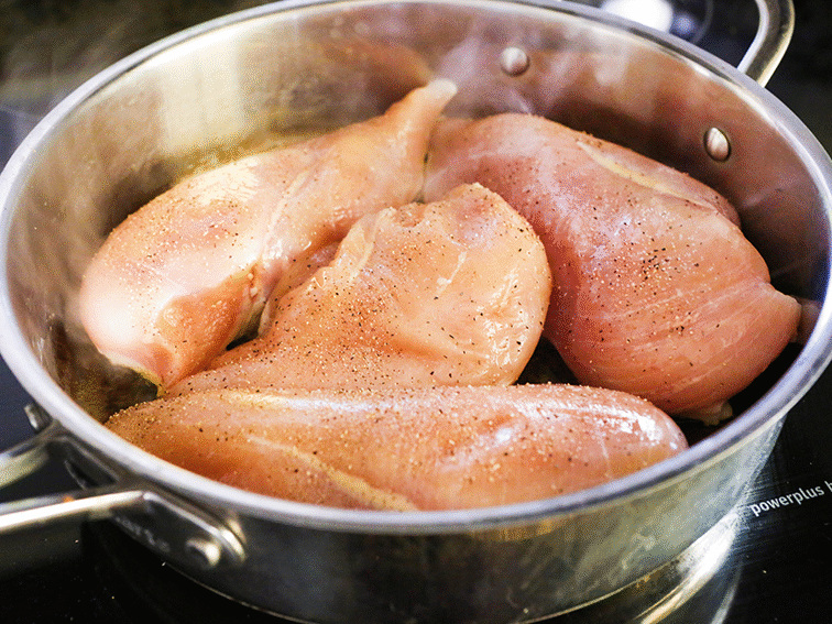 skillet packed full of uncooked chicken breasts
