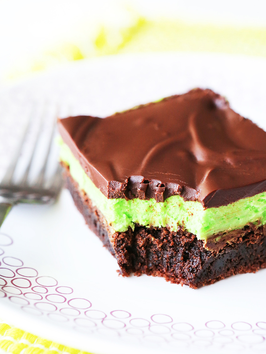 Brownie square with mint frosting on a plate and a fork next to it