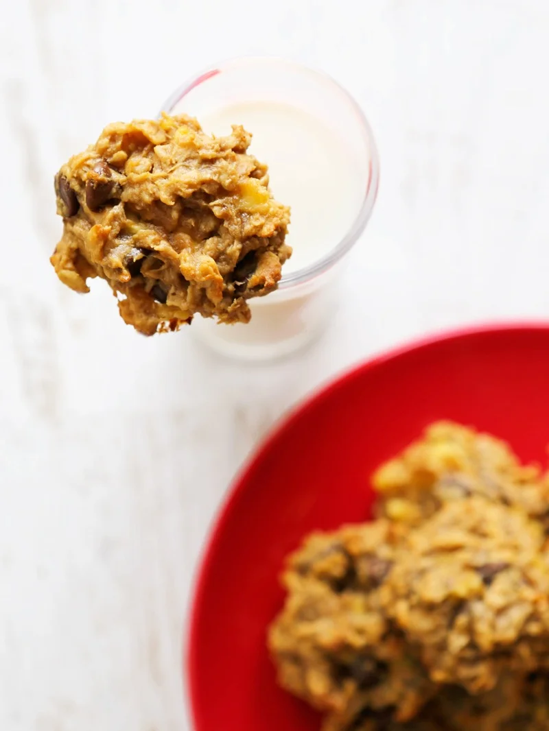 top view of a peanut butter banana cookie resting on a glass of milk