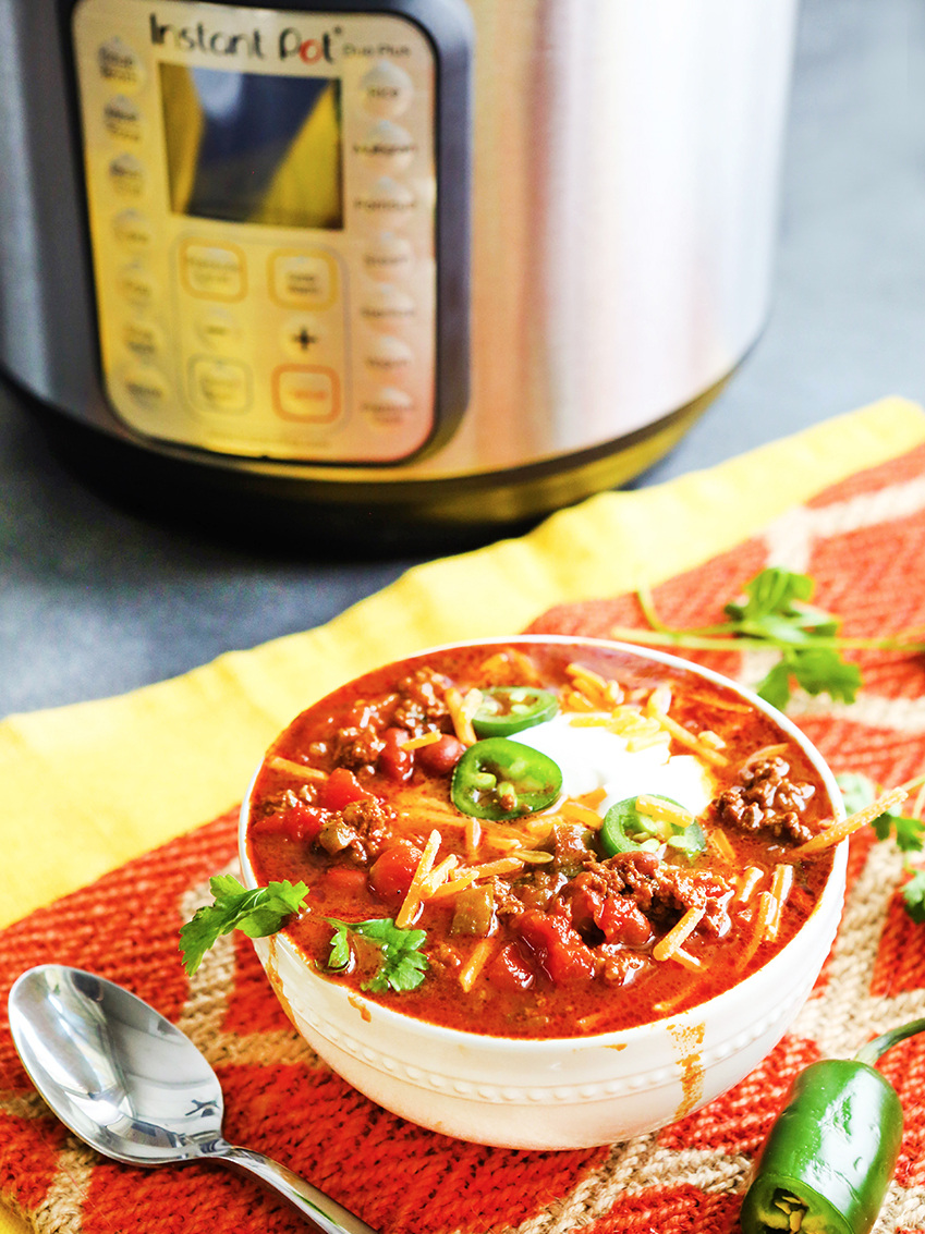 Bowl of chili sitting next to an Instant Pot 