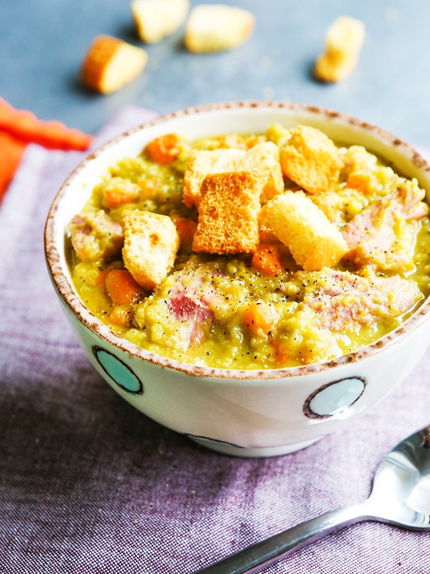 Bowl of split pea soup with apoon next to it