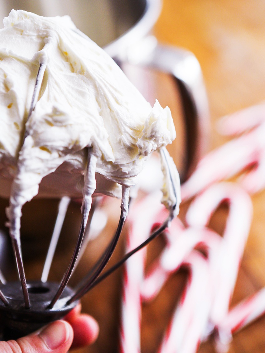 hand holding the whisk with peppermint buttercream on top