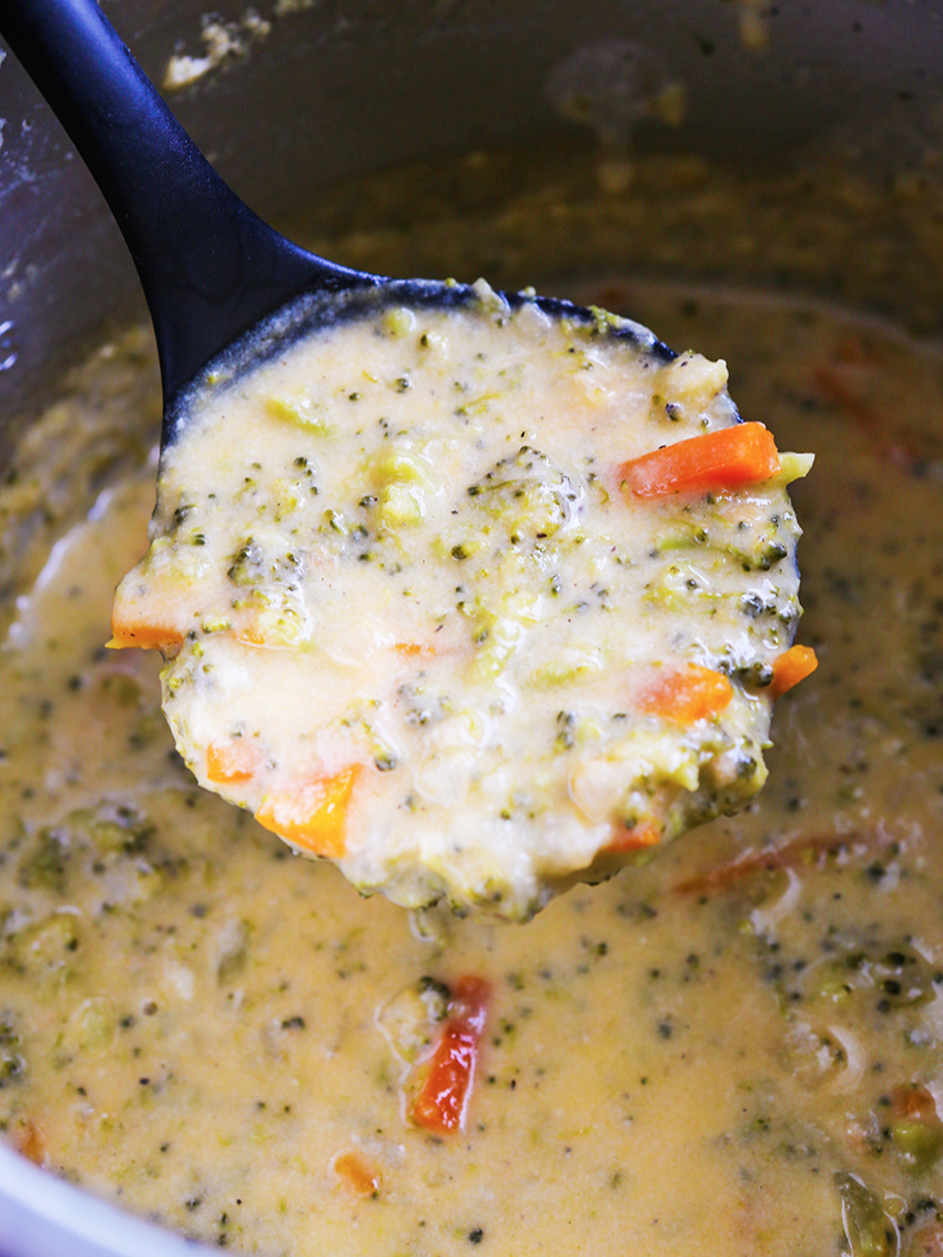  Ladle full of broccoli cheese soup hovering over Instant Pot 