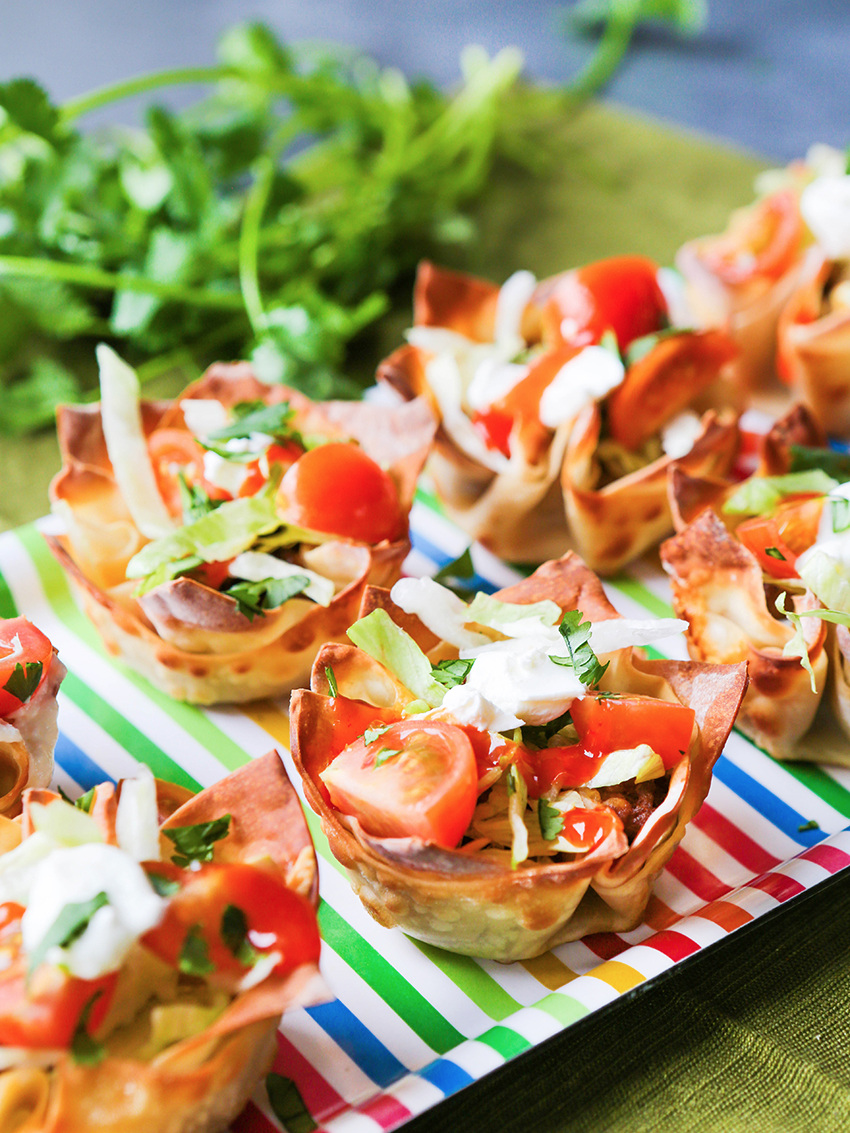 Close up of a tray of loaded taco cups on the table cloth