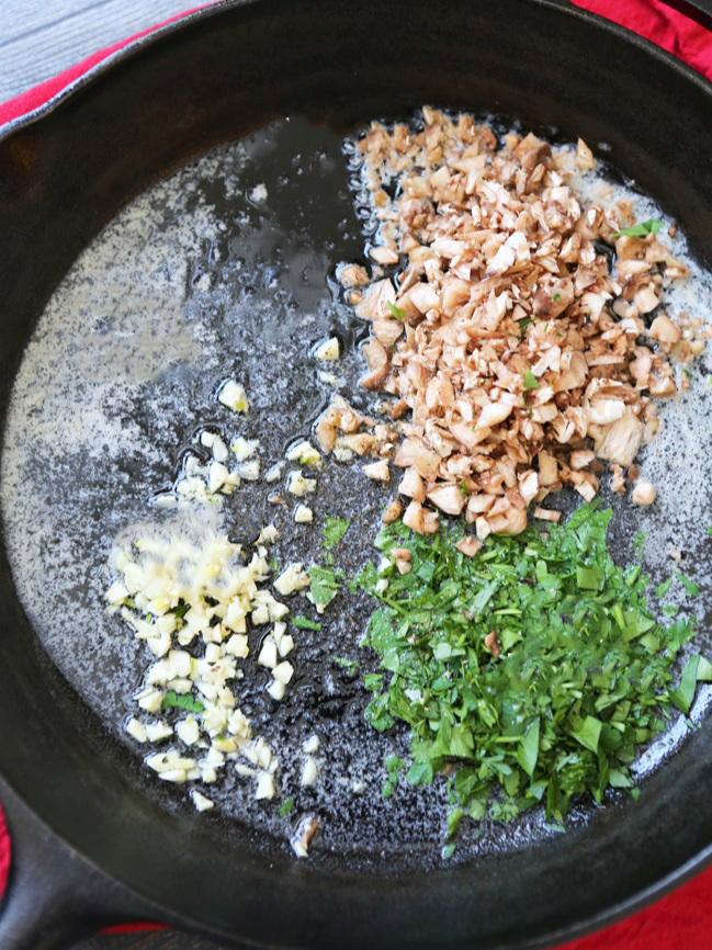  Mushrooms, parsley and garlic in a skillet 