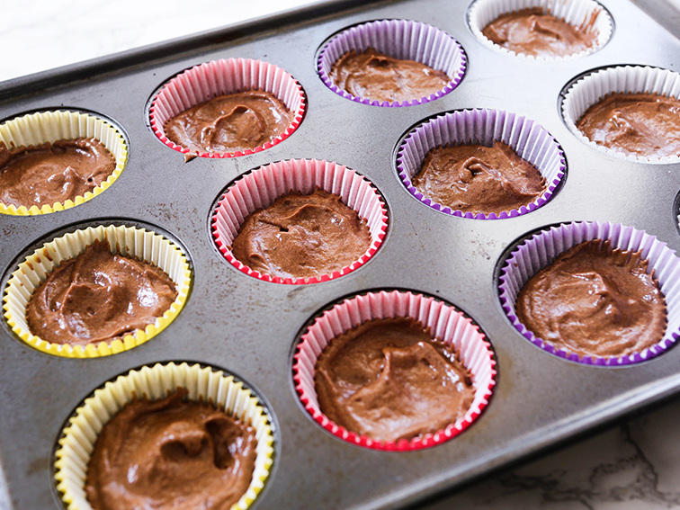 Cupcake tine with liners filled half full of batter