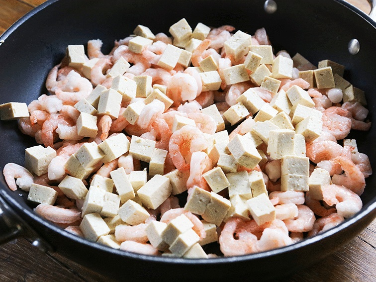 Pan with cubed tofu and uncooked shrimp