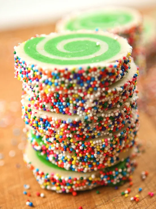 stack of sprinkled cookies cut and ready to bake
