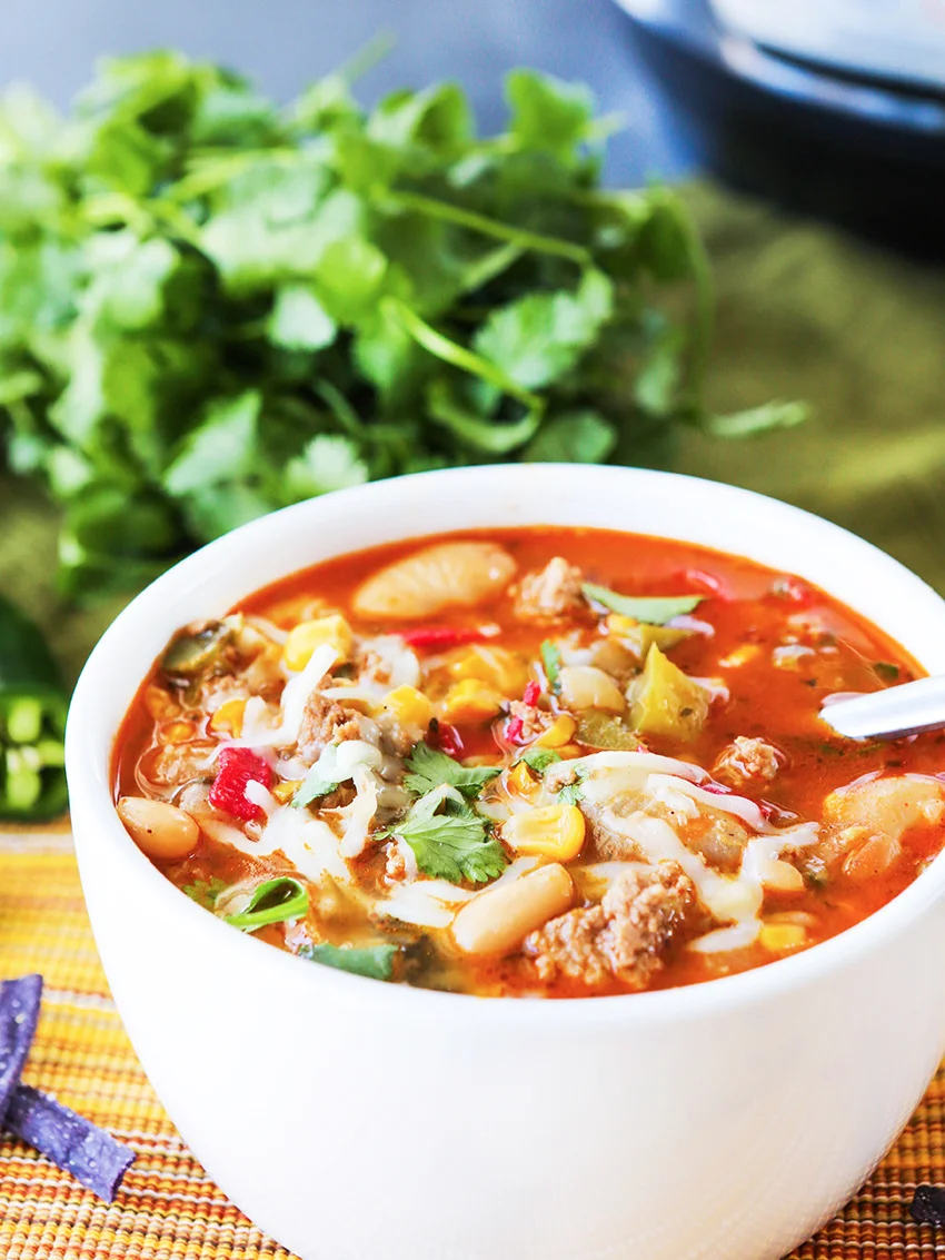  Bowl of chili with bunch of cilantro and Instant Pot in background 