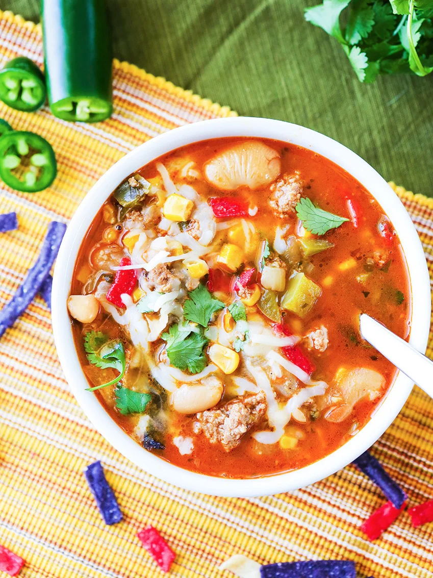  Top view of bowl of chili with toppings and spoon in bowl 
