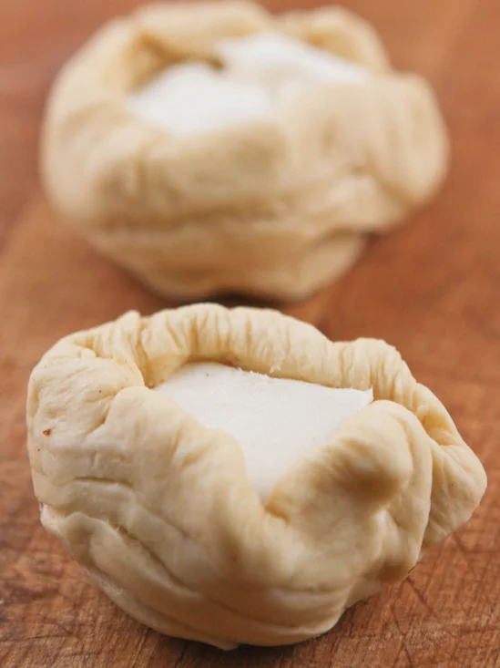 dough wrapped up around a cube of cream cheese