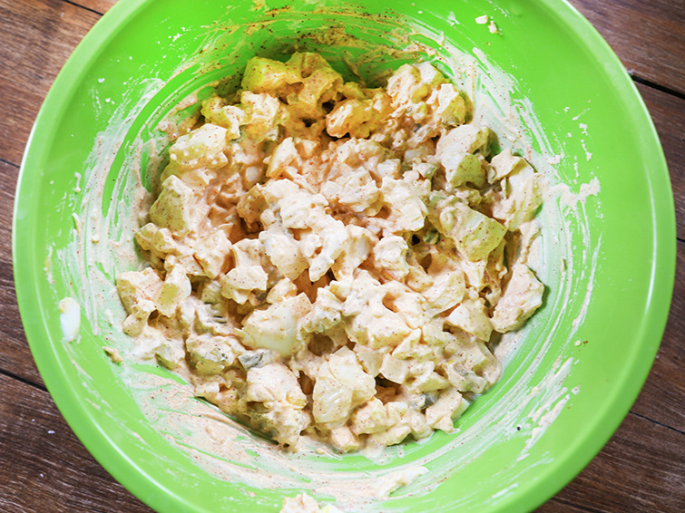 A green bowl with egg salad mixture inside