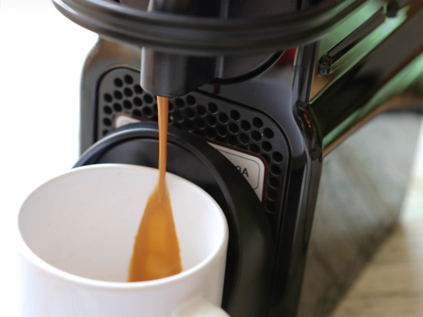 Coffee pouring out of Nespresso into a mug