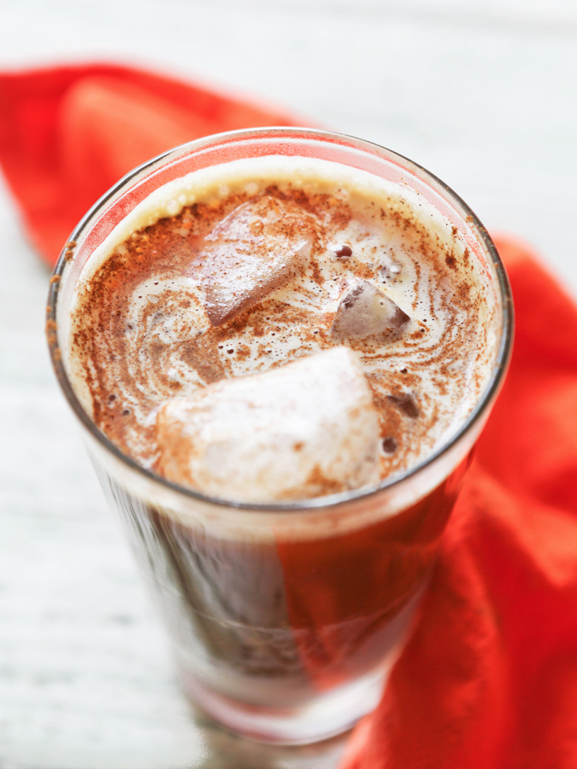 Tall glass with ice and a latte inside