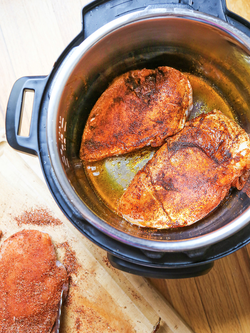 Top view of chicken breasts being sauteed in Instant Pot 