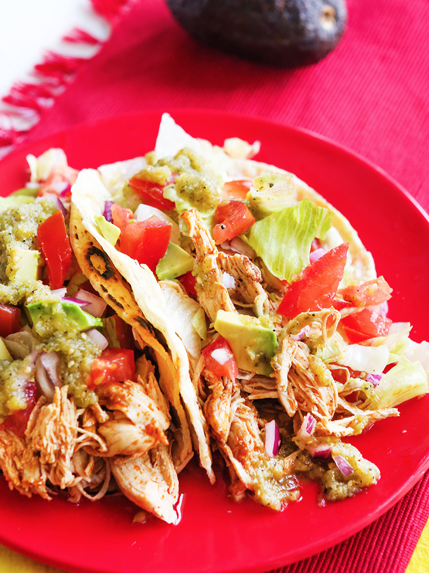 Top view of chicken tacos with tomatoes and lettuce 