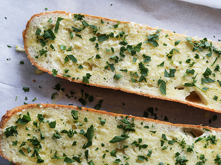 French bread with butter and parsley spread on top 