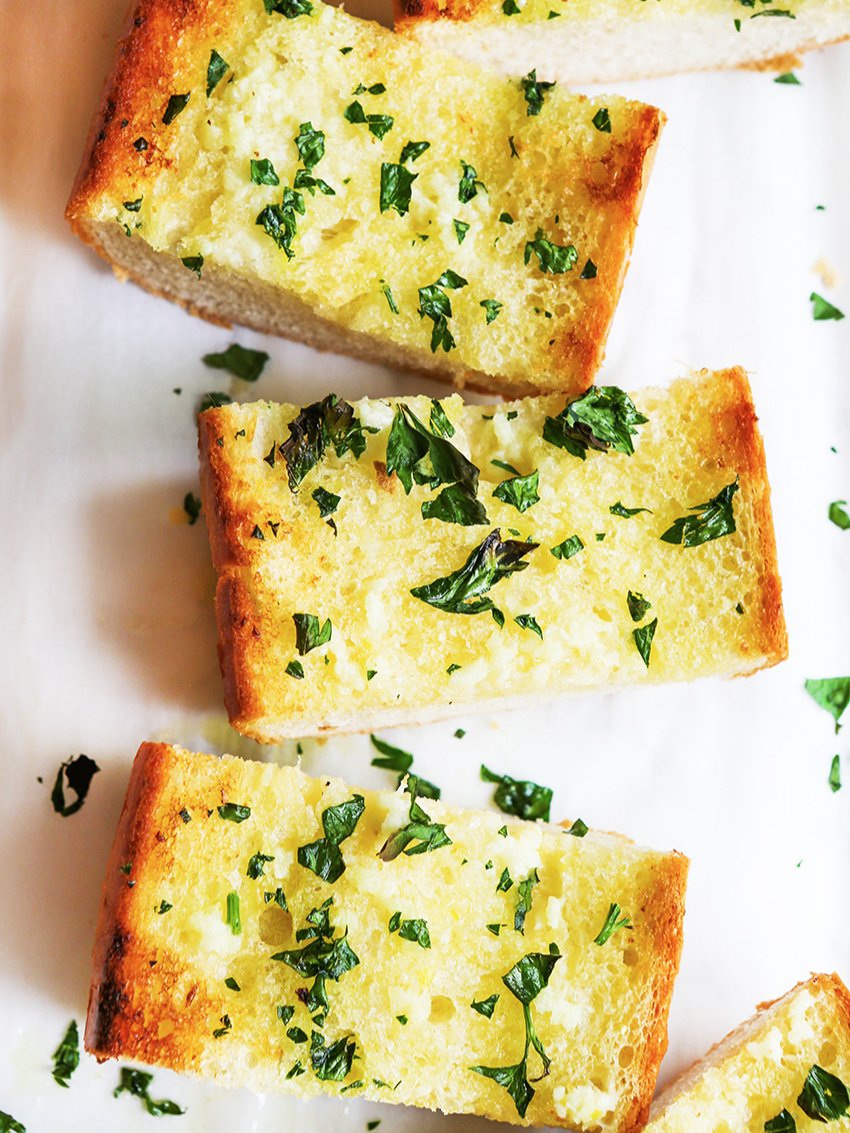  Looking down on pieces of buttery garlic bread with parsley 