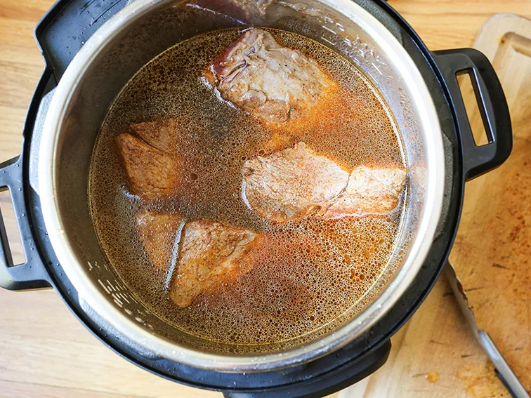 top view of the roast in the instant pot sitting in beef broth