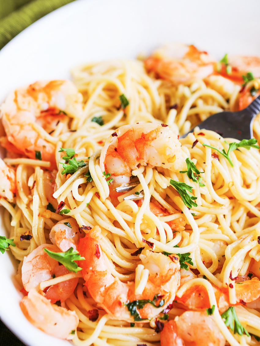 Close up of a plate piled high with pasta and shrimp