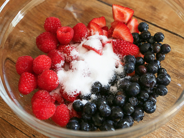 berries in a mixing bowl with sugar