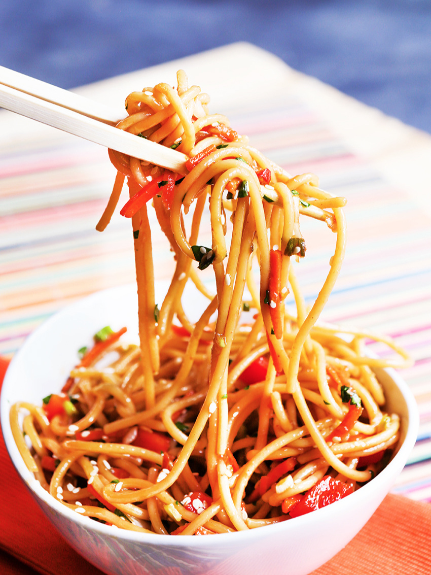  Chopsticks lifting noodles out of a bowl 