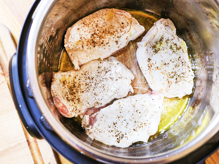  Four pork chops being sauteed in Instant Pot 