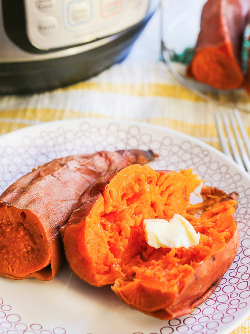 Instant Pot sweet potatoes on a plate with a pat of butter and an Instant Pot in background
