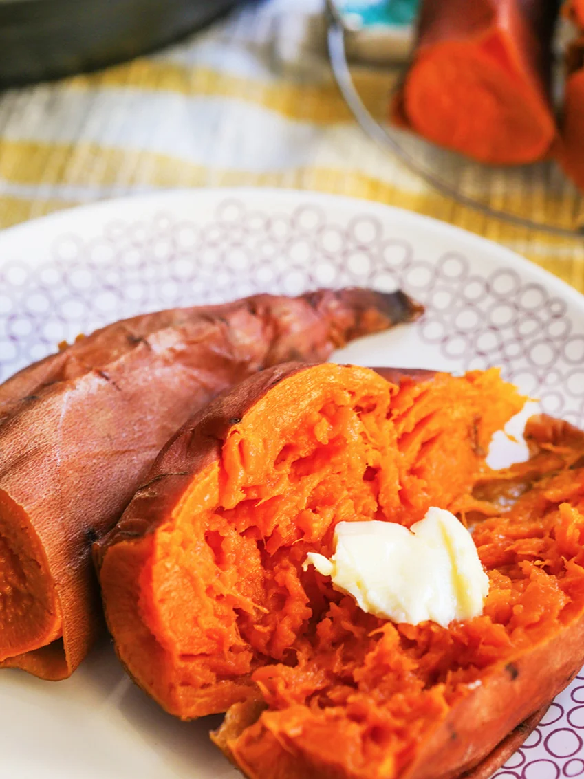 Instant Pot sweet potatoes cut in half with a pat of butter melting inside