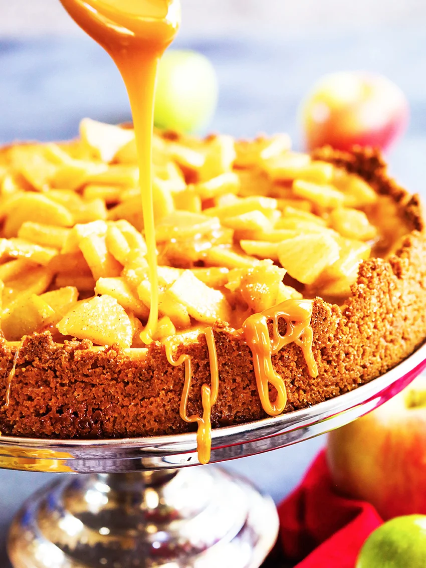caramel being drizzled over a cheesecake