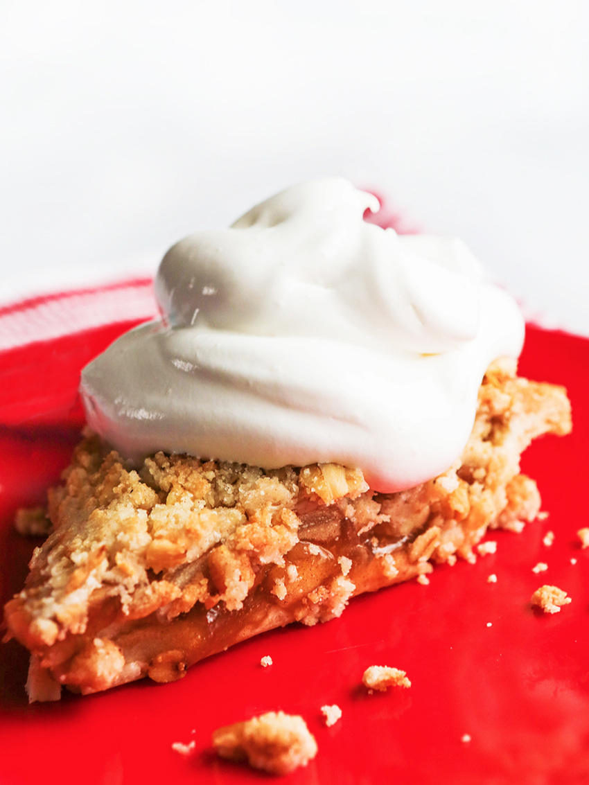 slice of apple pie with a heaping pile of whipped cream on top