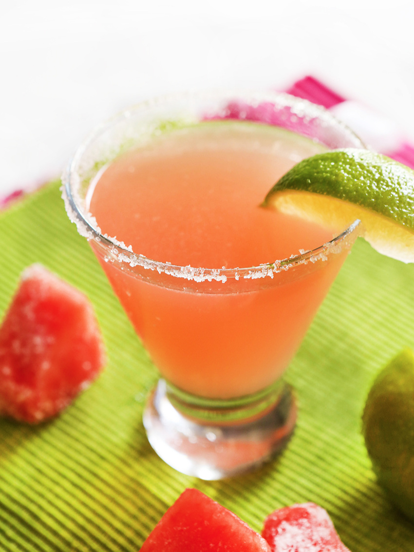 watermelon martini in a glass with a slice of lime garnish