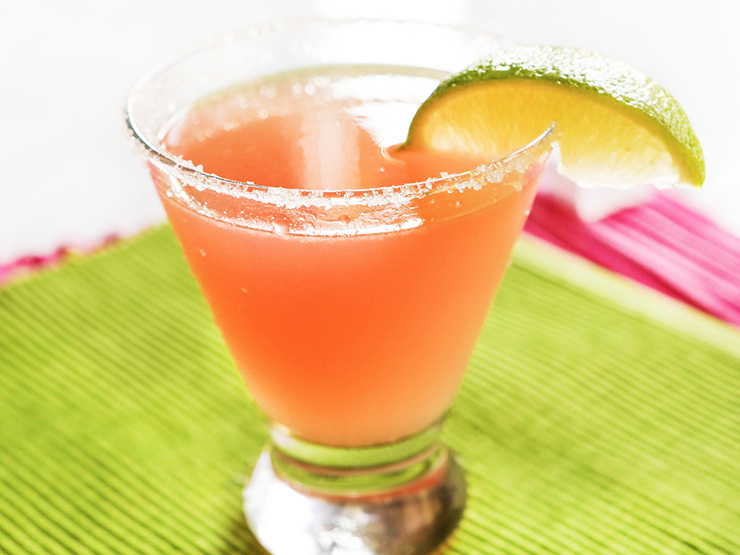 alternate view of a watermelon martini with a lime garnish