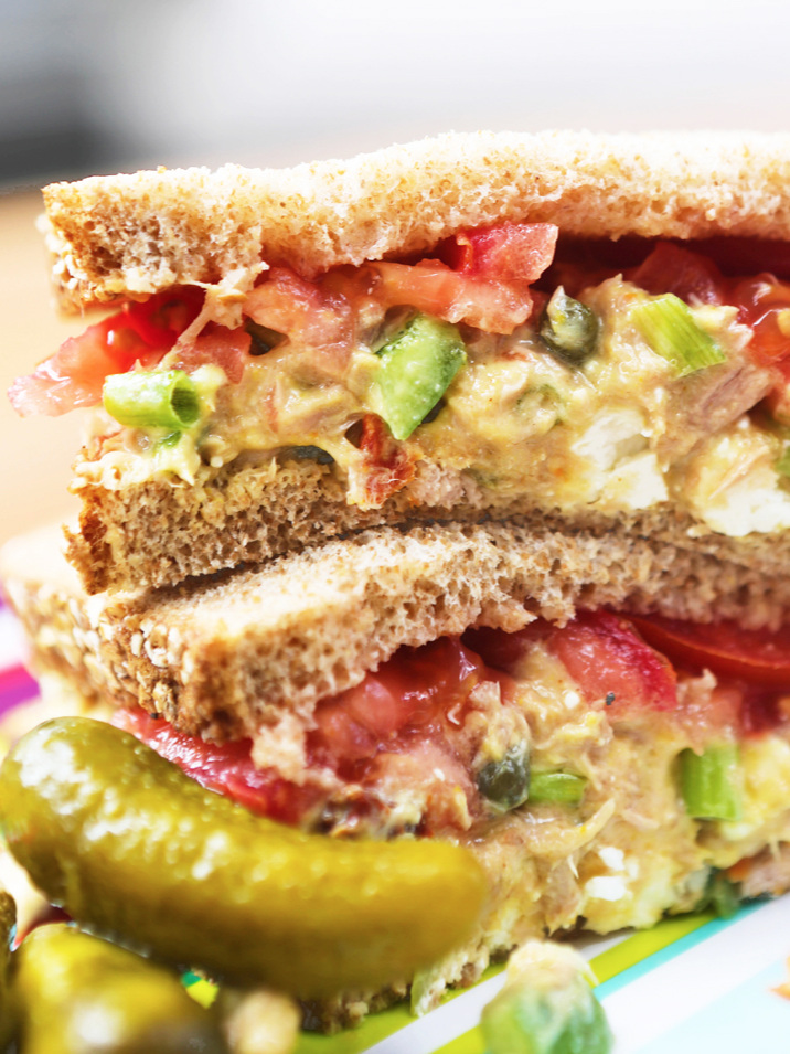  Close up of a tuna salad sandwich and pickles 