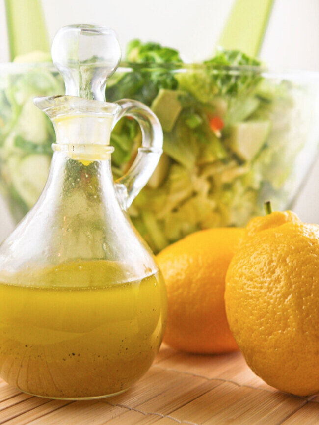  Container lemon vinaigrette with salad in background 