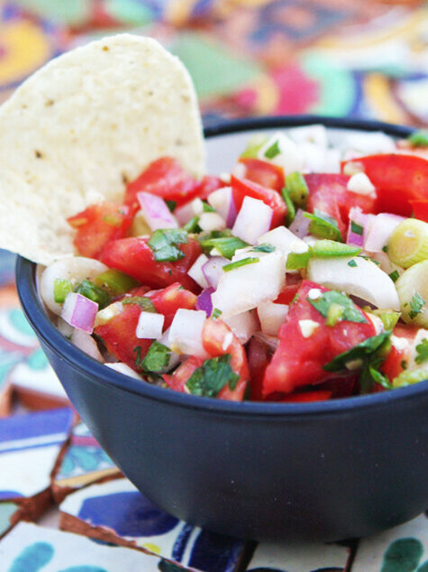  Bowl of fresh salsa with a tortilla chip sticking out 