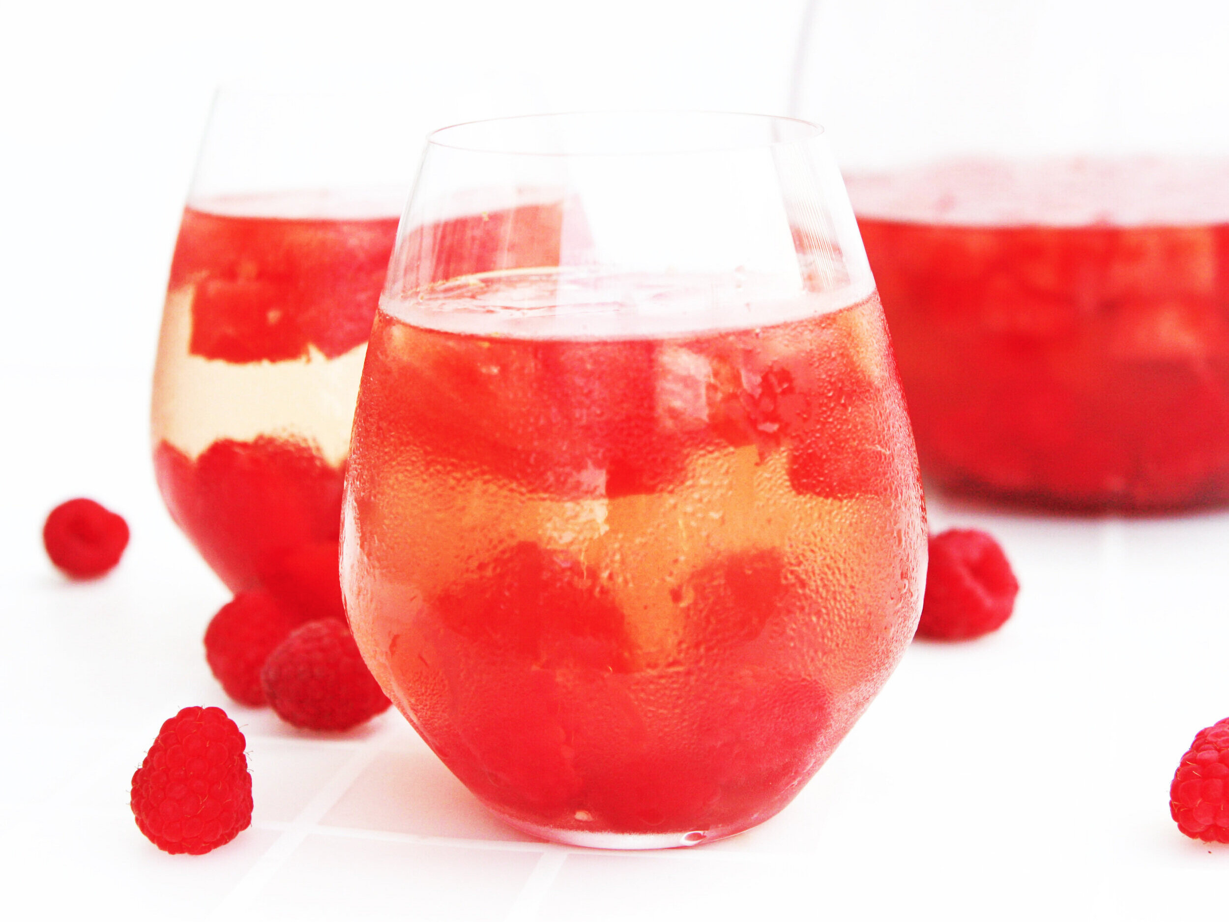  two glasses of raspberry sangria with raspberries inside 