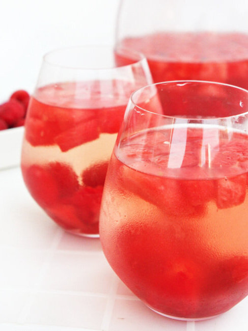  Two glasses of sangria sitting by pitcher 