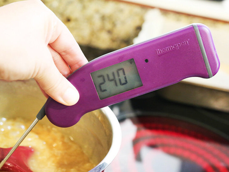  hand holding thermapen in a pan of boiling caramel 