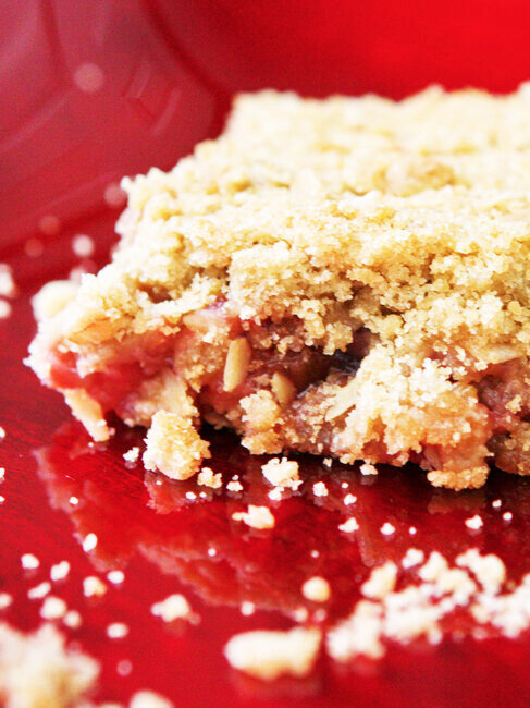  close up of rhubarb crunch bar on a bright red plate 