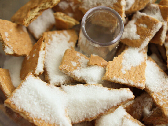  Broken graham crackers and sugar in bowl of a food processor 